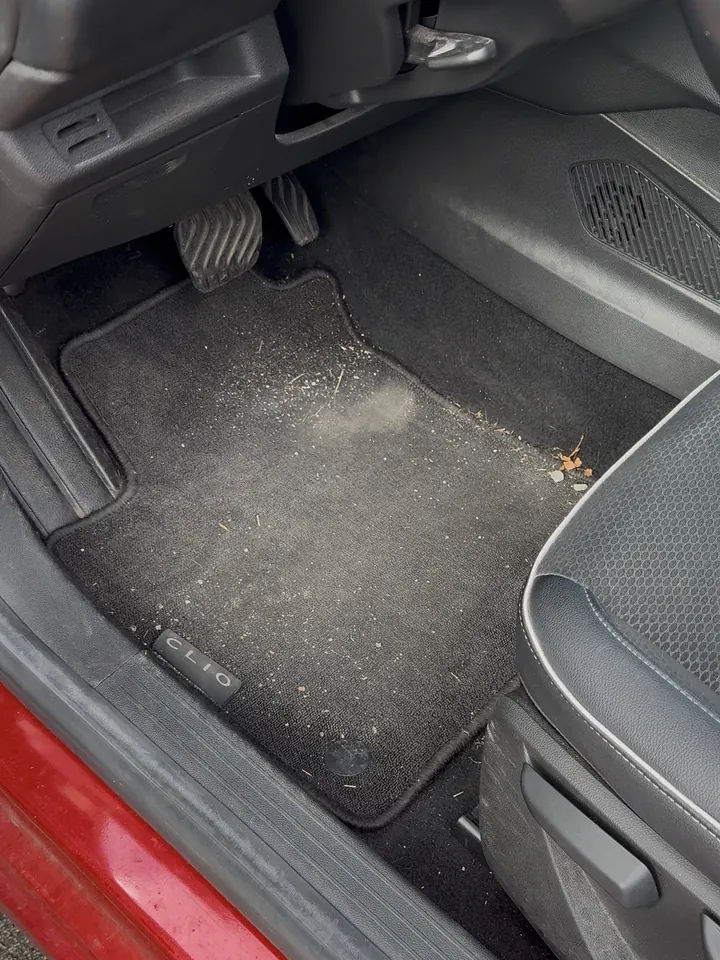 Renault Clio, tapis conducteur avant nettoyage, couvert de poussière et de débris